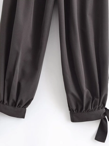 Close-up of charcoal grey jogger cuffs featuring decorative bow knots and woven texture