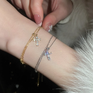 Close-up of elegant gold and silver cross bracelets with sparkling cubic zirconia