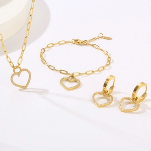 Macro shot of gold paperclip chain jewelry set featuring zircon-encrusted heart pendants