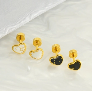 Détail de boucles d'oreilles cœur avec paillettes dorées et fermoir à vis