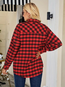 Detail of red and black plaid shirt showing back view and cotton texture on model