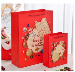 Detail of red Merry Christmas paper gift bags in two sizes with bell and snowflake patterns