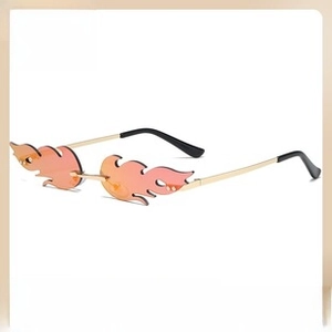 Detail of frameless flame-shaped sunglasses with gradient orange-pink lenses and gold metal arms