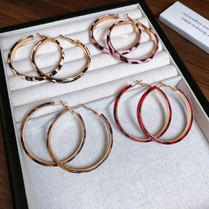 Detailed view of four pairs of leopard print hoop earrings on a velvet jewelry tray