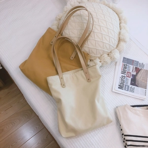 Minimalist canvas tote bags in yellow and beige colors with leather shoulder straps