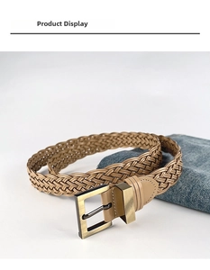 Detail of hand-woven khaki waist belt featuring a vintage brass square buckle and denim
