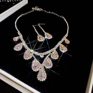 Macro shot of silver teardrop pendant necklace and earrings set with sparkling crystals