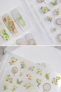 Macro detail of 5D floral and butterfly nail stickers with gold foil and fans