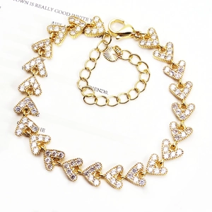 Close-up of golden heart-shaped bracelet with micro-paved zircons and adjustable clasp