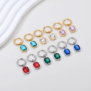 Flat lay of colorful rectangular crystal drop earrings in gold and silver finishes