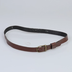 Detail shot of the vintage copper metal buckle on the brown leather hat belt strap