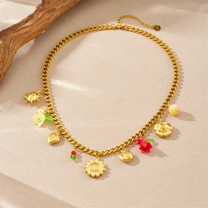 Collier en acier inoxydable doré avec pendentifs tournesol et pomme sur fond texturé