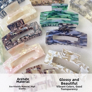 Detailed overhead view of multiple large acetate hair claws with marbled textures and patterns