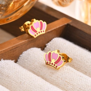 Macro shot of crown-shaped stud earrings in gold with pink enamel and heart details