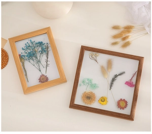 Detail of wooden shadow box frames with dried flowers in light and dark brown finishes