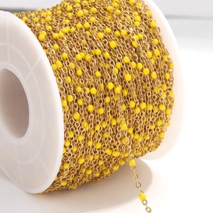 Detail of yellow enamel beads on a gold-plated stainless steel chain for DIY jewelry