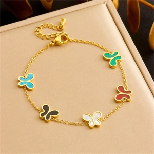 Elegant gold butterfly necklace with colorful gemstone pendants on beige jewelry tray