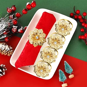 Set of 6 gold flower napkin rings with crystal center on a festive red napkin