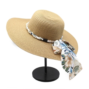Elegant wide brim straw sun hat featuring a floral ribbon and faux pearl decoration