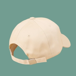 Detail of adjustable metal buckle and cotton twill texture on the beige baseball cap