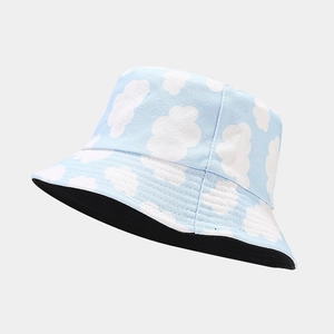 Blue reversible bucket hat with cloud pattern made of breathable canvas for summer sun protection