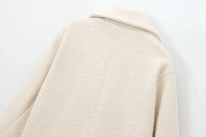 Close-up of the collar and back shoulder stitching on a beige wool double-breasted coat