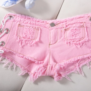 Dettaglio degli shorts in denim rosa con orli sfrangiati e lacci laterali metallici