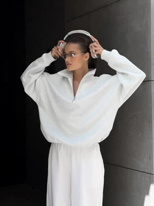 Close-up of oversized half-zip sweatshirt with metal zipper and soft cotton texture