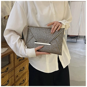 Pochette enveloppe chic à paillettes dorées tenue par un mannequin pour look de soirée