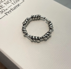 Close-up of S925 sterling silver ring with twisted rope design on white gift box