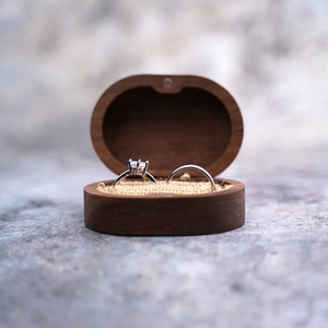 Macro detail of walnut wood double ring box with two elegant silver diamond rings