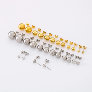 Détail montrant différentes tailles de boucles d'oreilles boules dorées et argentées