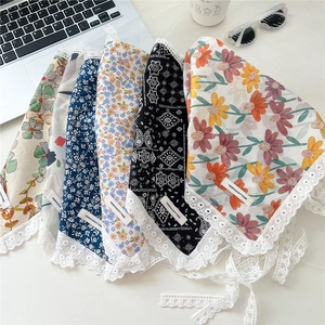Detail of 100% cotton floral headscarf featuring delicate white lace trim and labels