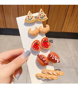 Detailed close-up of pizza, hot dog, and croissant hair clips set on display card