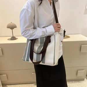 Minimalist grey striped canvas tote bag with long brown straps for daily commuting wear