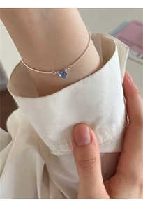 Dettaglio di un bracciale a catena serpente in argento 925 con zircone blu a forma di cuore