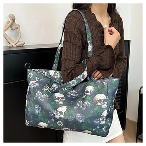 Detailed view of large tote bag featuring gothic skull and purple floral print on black
