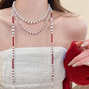 Detail view of double-layer necklace with white faux pearls and red beads accent