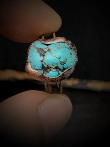 Macro shot of irregular natural turquoise stone set in a vintage bronze adjustable ring