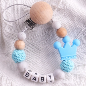 Detail of beechwood pacifier clip with blue crochet bead, silicone crown and BABY beads
