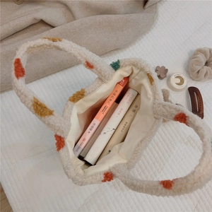 Top view of plush polka dot handbag with books inside showing spacious interior