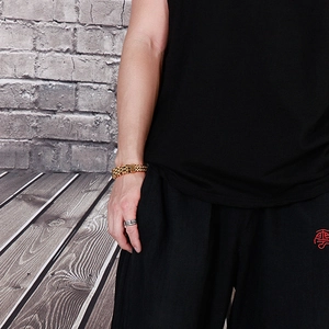 Close-up of a double-layered golden chain bracelet and textured silver ring on a model