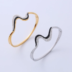 Detail of wave design bangles with black and white pavé crystals in gold and silver