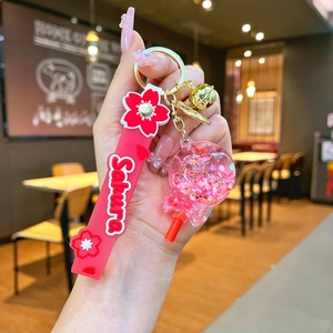 Detail of pink Sakura silicone wristband with glitter ball pendant and golden bell