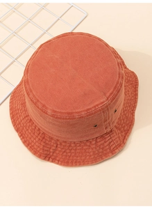 Détail d'un chapeau bob orange en toile délavée avec œillets d'aération et coutures