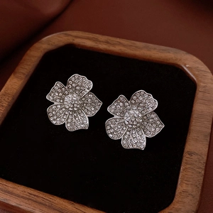 Close-up of vintage flower earrings with sparkling diamonds on a black velvet display