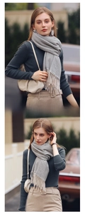 Detail shot of a grey herringbone knit scarf with fringe trim for winter fashion styling