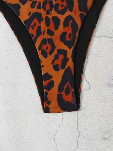 Macro detail of high-elastic orange leopard print bikini bottom with black piping