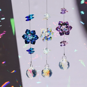 Close-up of crystal suncatchers featuring maple leaf designs and vibrant rainbow prisms