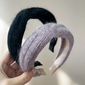 Close-up of thick knitted plush headbands in black and lavender with mohair texture